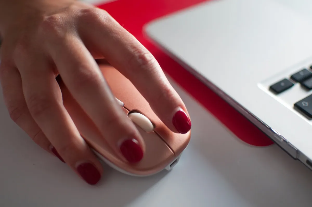 A close-up of a hand clicking a computer mouse, representing the clicks and taps that autocapture tools record automatically.