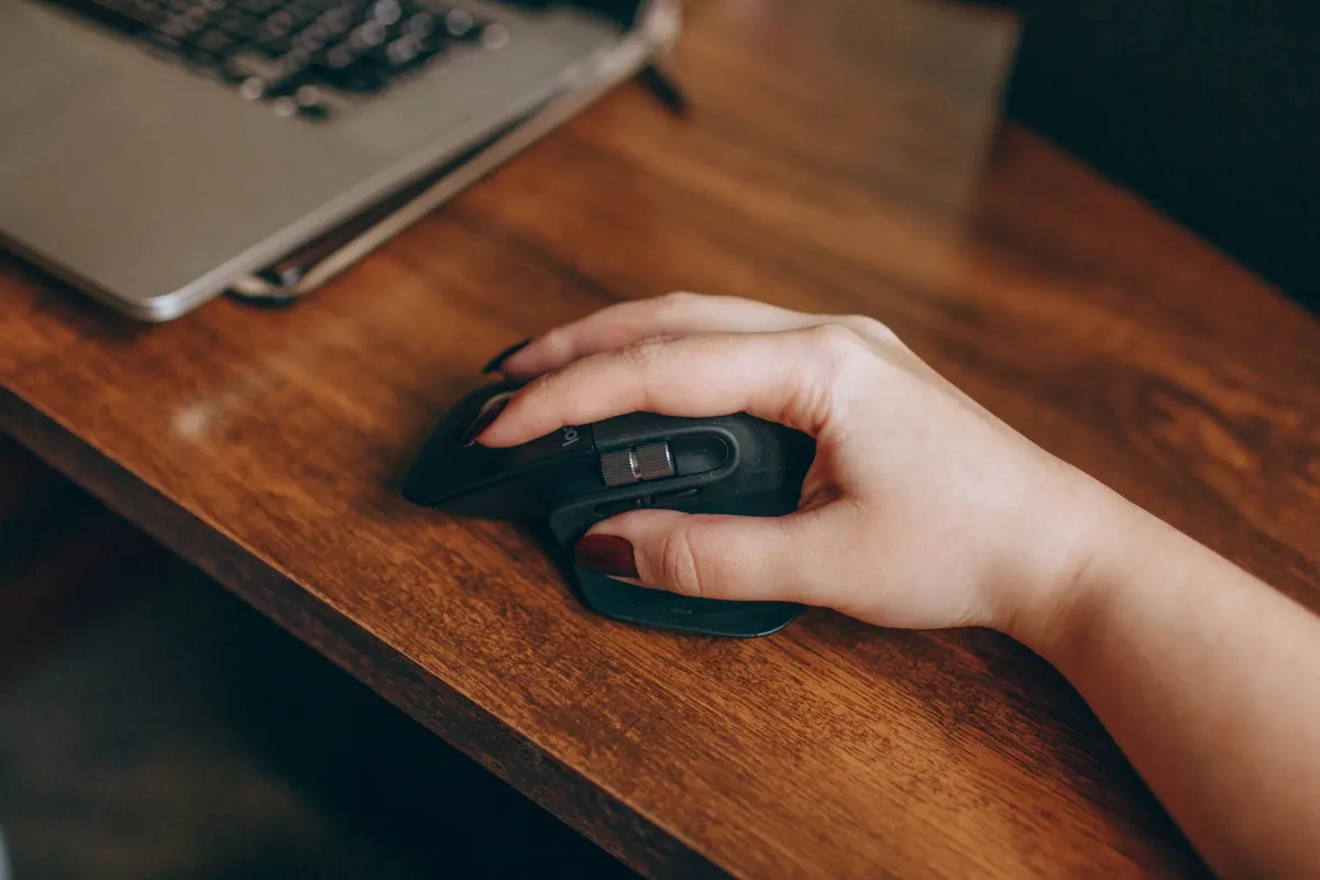 Une personne clique plusieurs fois avec sa souris à son bureau, le genre de comportement qui apparaît dans un groupe de clics de rage.