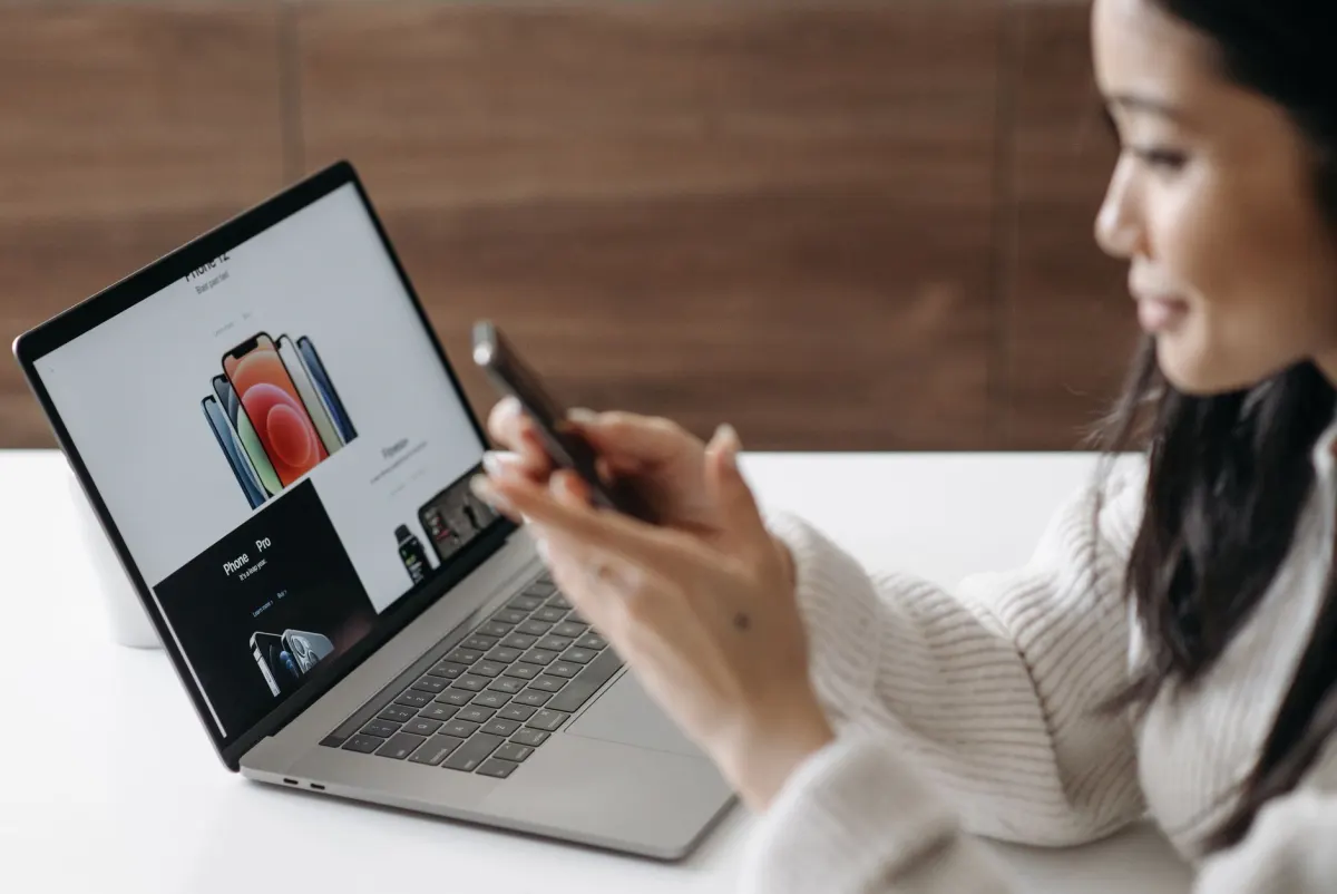 A person taps an ad on a phone, the exact click-to-landing-page moment that can trigger the shorter 24-hour cookie cap.