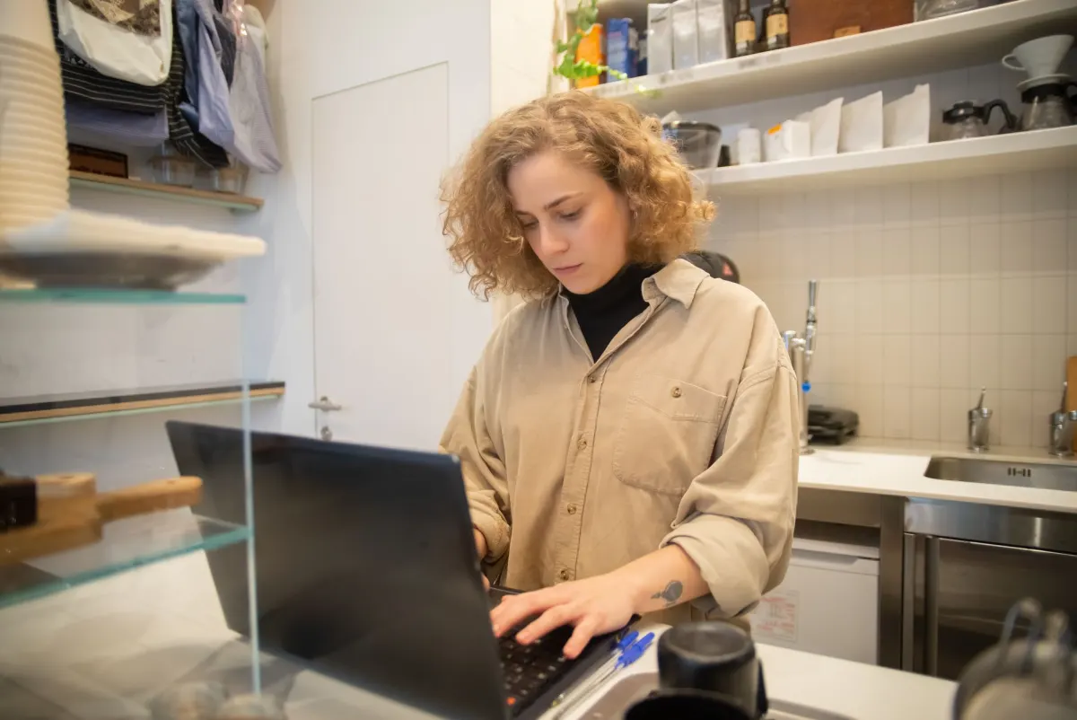A solo founder works from a laptop in a small cafe, the kind of maker DataFast builds its revenue-tracking tools for.