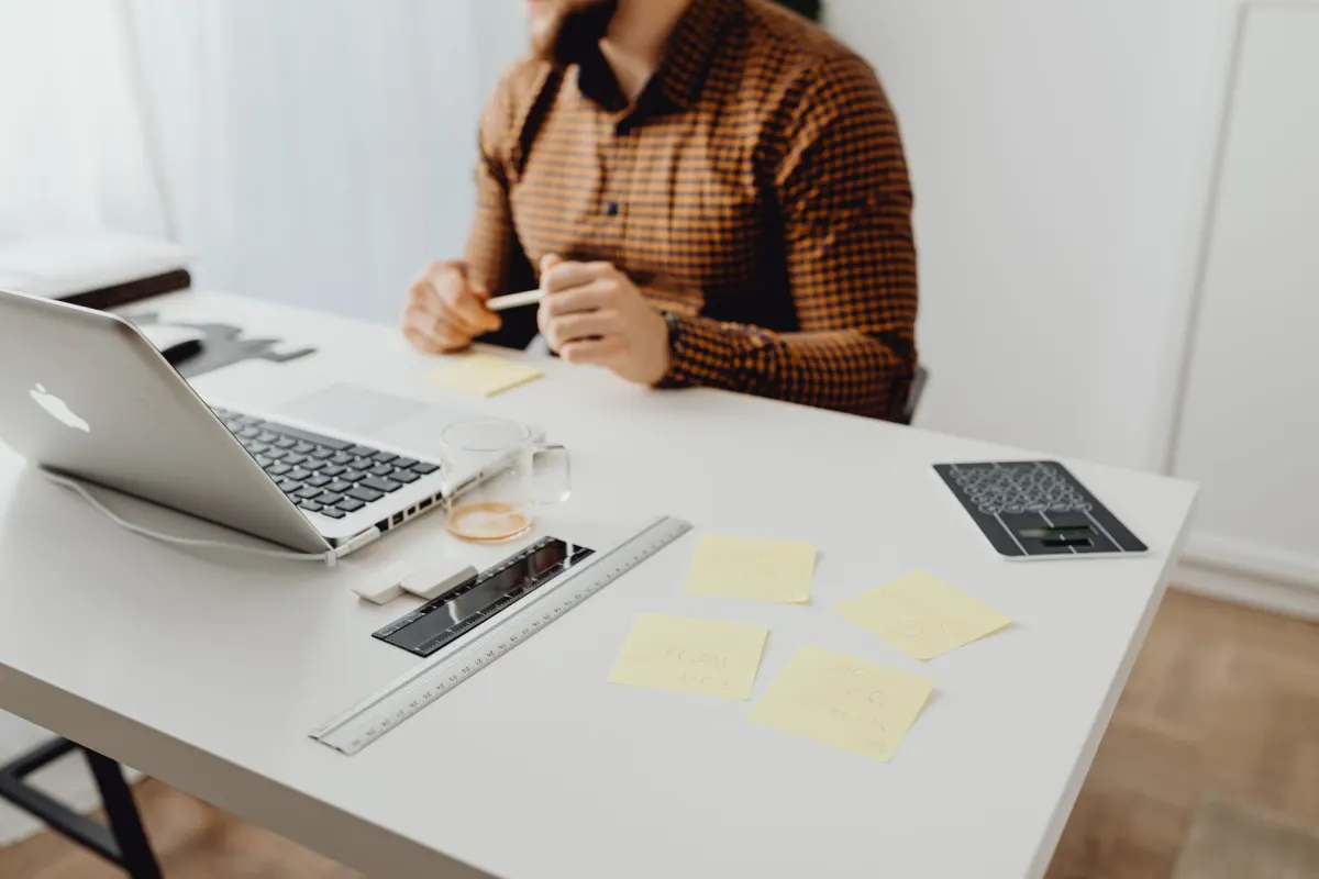 Une personne travaille sur un ordinateur portable dans un bureau, illustrant les tests manuels nécessaires pour vérifier le comportement de la bannière de consentement.