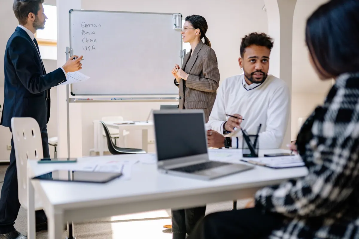 Ein Team bespricht Traffic-Daten an einem Whiteboard, so wie Webanalyse-Zahlen zu Entscheidungen werden.
