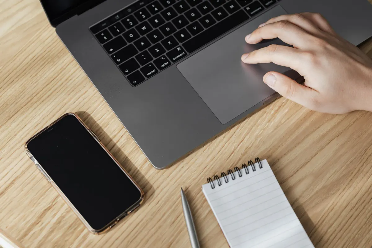 A person clicks a laptop trackpad, the kind of interaction a click map records as a warm spot.