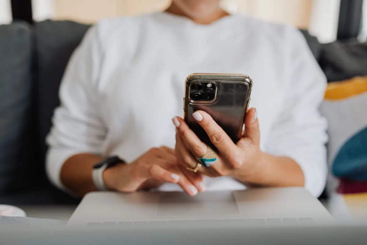 A woman types on her phone, illustrating the coded wording people use to keep posts online.