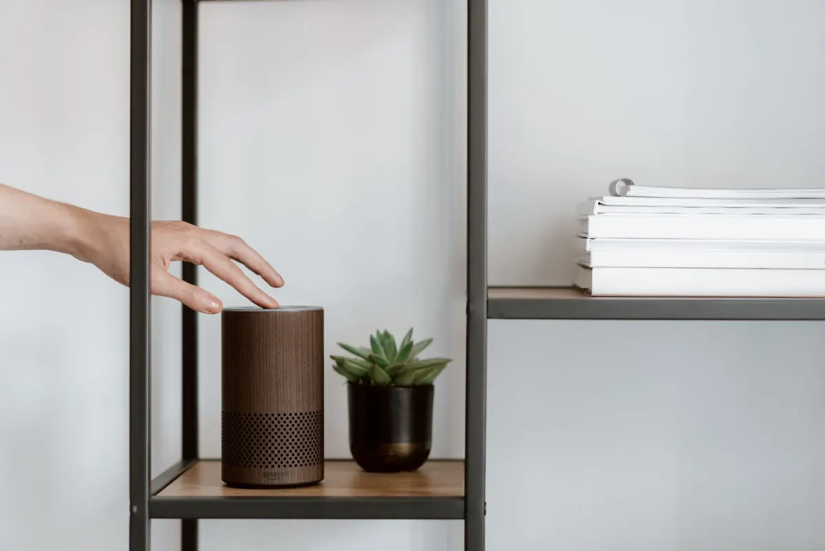 Eine Person nutzt zu Hause einen smarten Lautsprecher, im Zusammenhang mit der Trennung von Amazonbot und der Alexa-Suche.