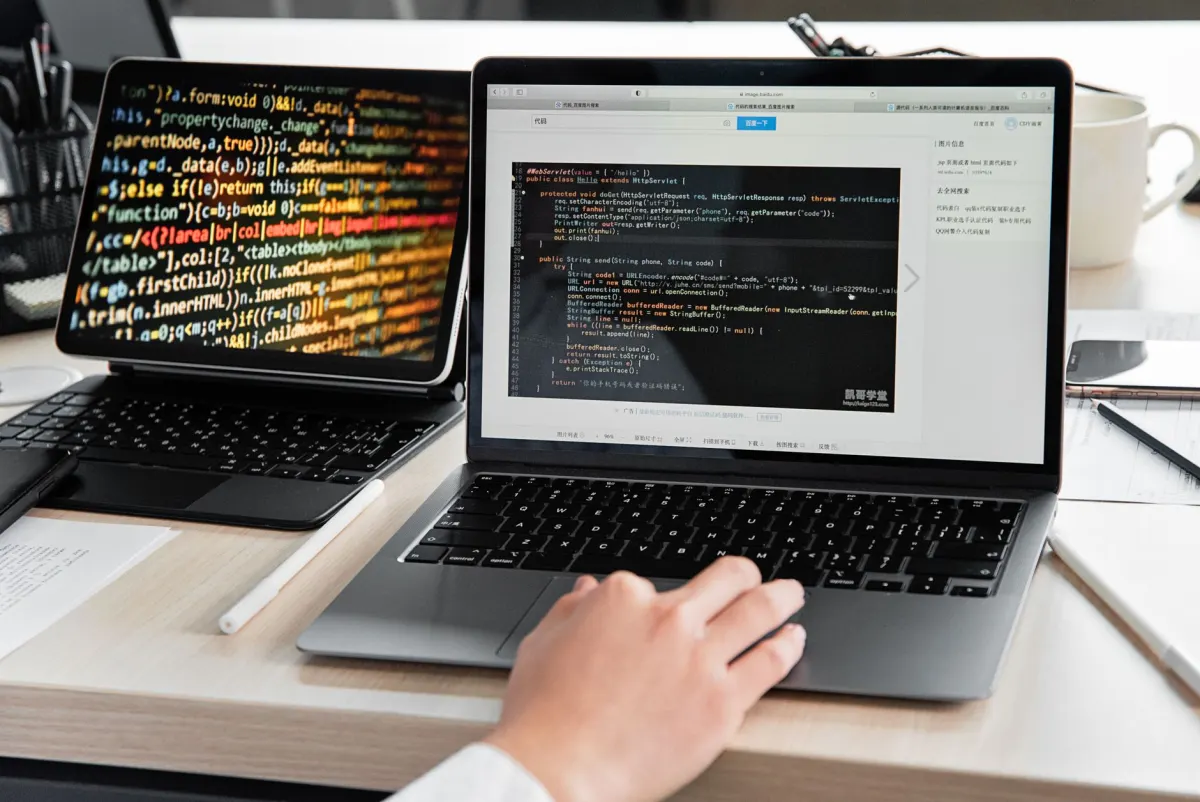 Eine Person, die gleichzeitig an mehreren Laptops tippt, steht für das koordinierte Postmuster von Astroturfing auf X.