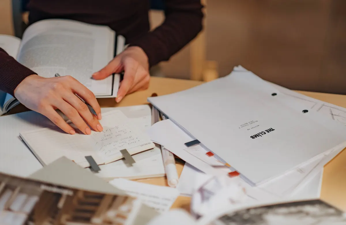 A marketer reading through notes at a desk before posting, matching the advice to check a community's rules first.