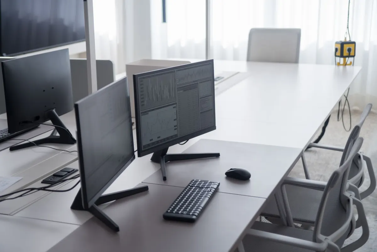 A desk with two monitors showing code, the kind of setup someone uses to build a bot or scheduling tool that needs its own credential.