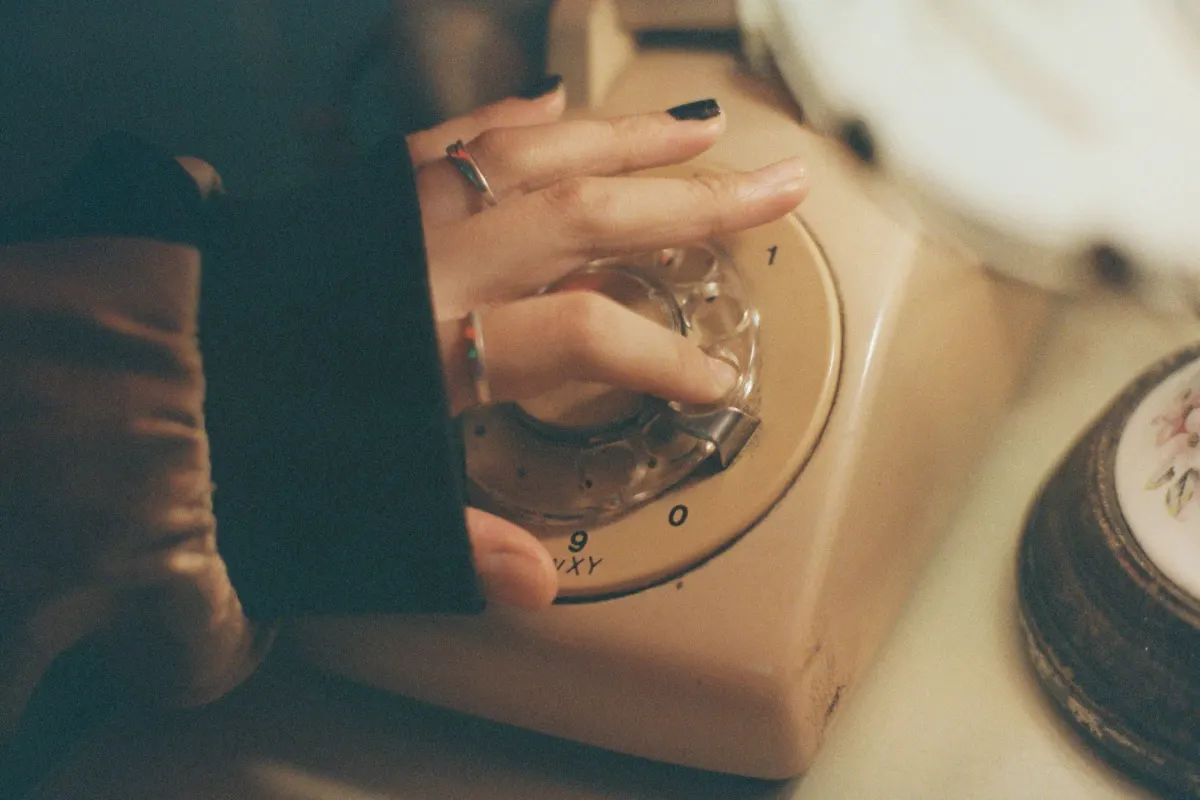 A hand flipping a phone's silent switch, showing how a mute quietly hides an account without telling anyone.