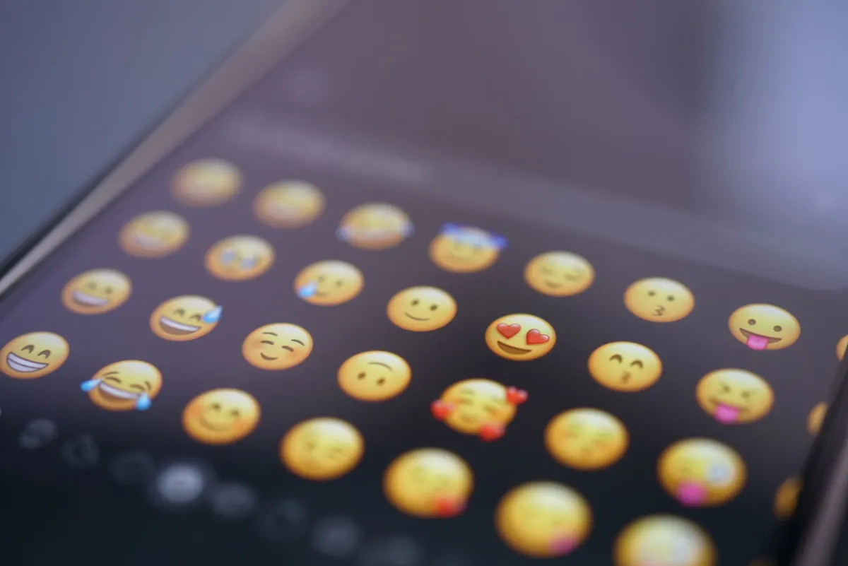 A close-up of a phone screen typing an emoji, illustrating how a single visible character can count differently than raw code units.