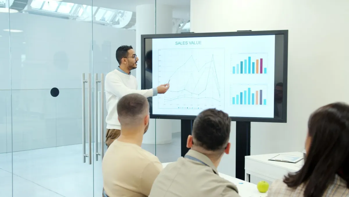 A small team gathered around a screen in an office, representing a sales or marketing team reviewing incoming alerts together.