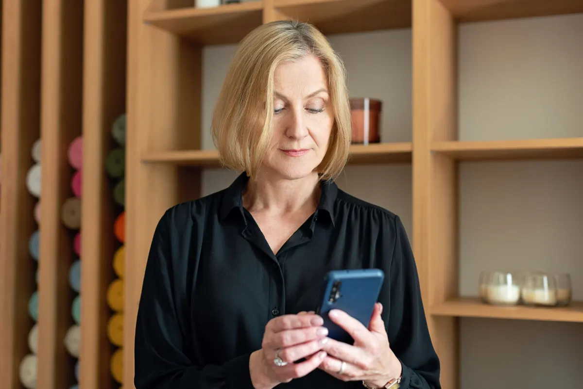 A person scrolling through posts on a phone, reflecting how ordinary members browse and post in a group.