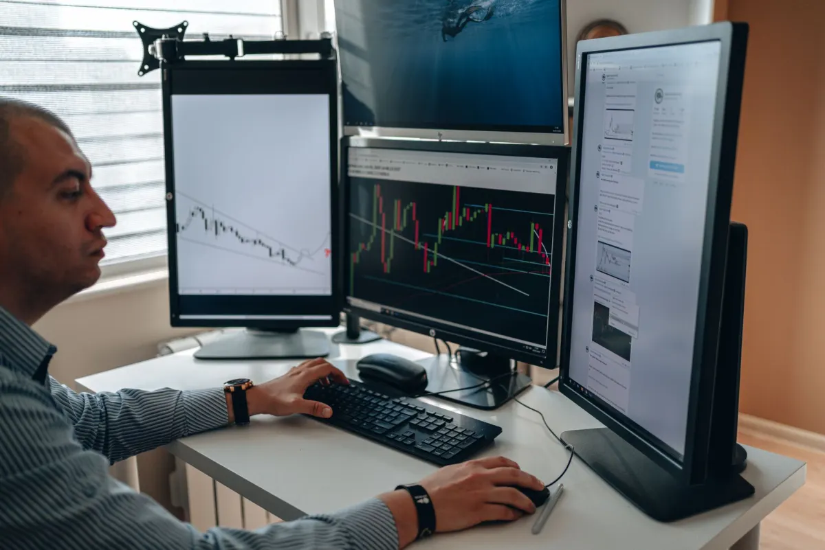 A person at a desk switching between several screens, showing the effort of reading many separate feeds one at a time.