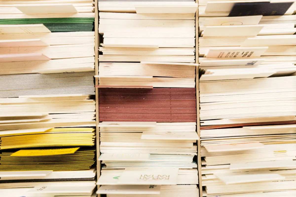 Hands sorting papers into separate piles, illustrating how counting and ranking mentions by source keeps a digest manageable.