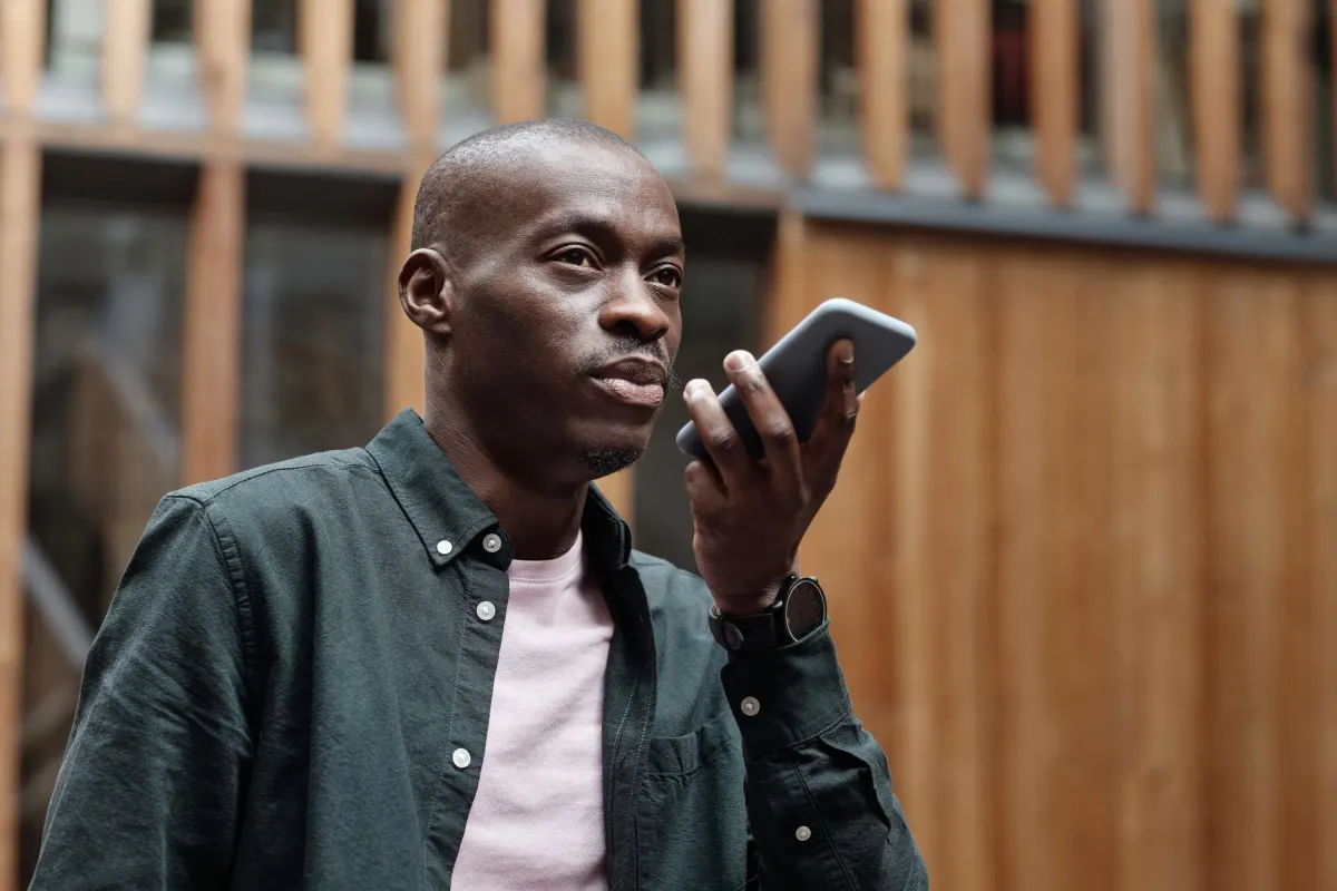 A person asks a question into a smartphone, showing how buyers now get answers from AI assistants instead of a list of search results.