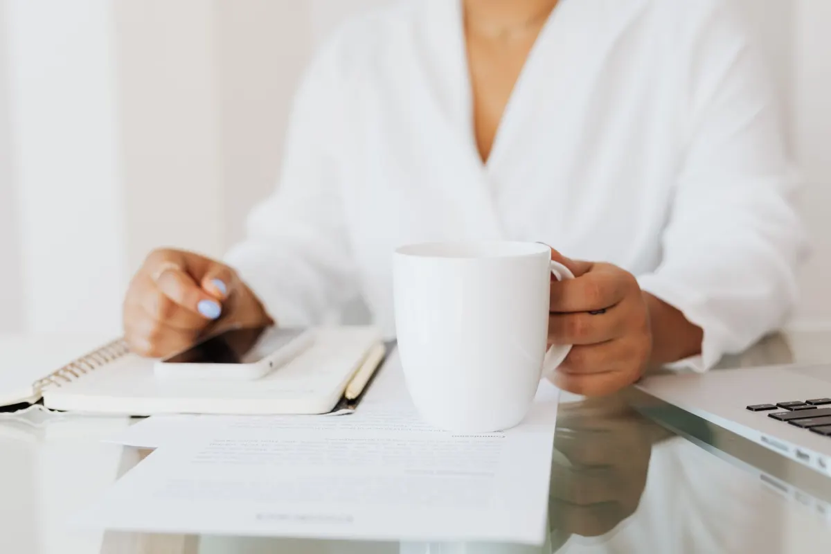 A person reading a report on a laptop at a desk with a coffee, like the morning lead digest a dot delivers.