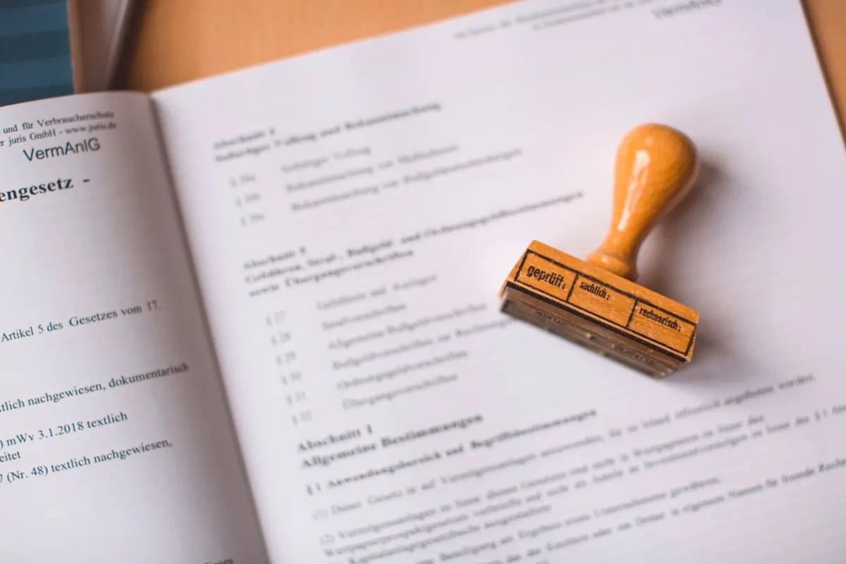 A hand signing a document at a desk, showing the human approval step that stays with you before anything is sent.