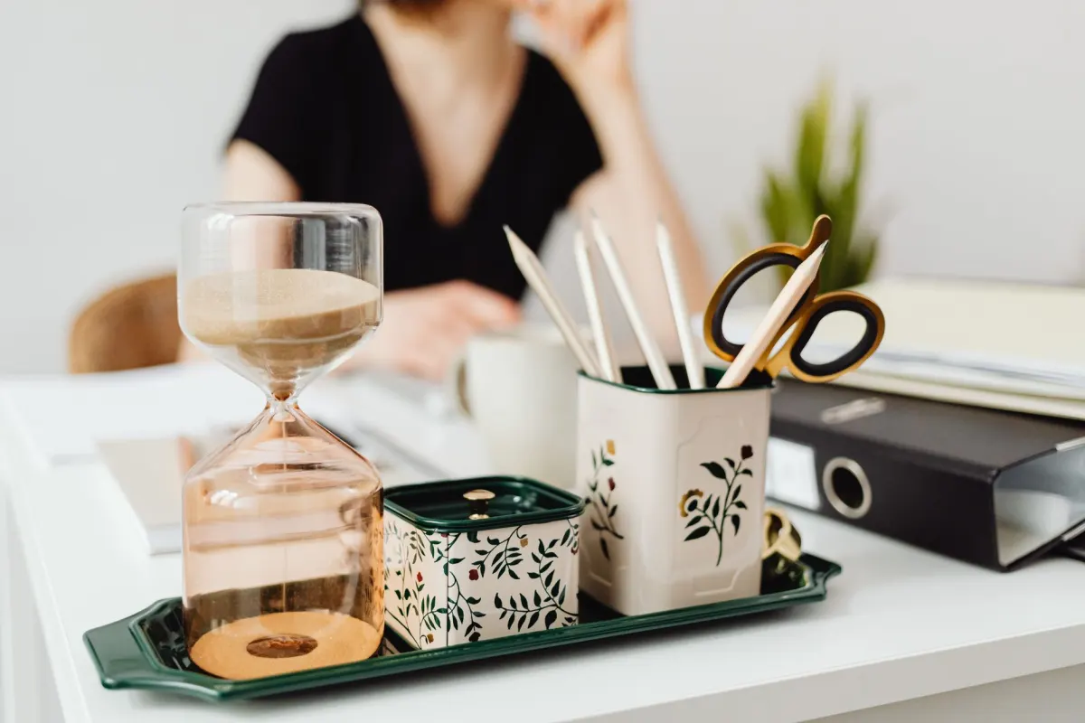 An hourglass on a desk marks the passage of hours, the same window Reddit uses to hide early votes.