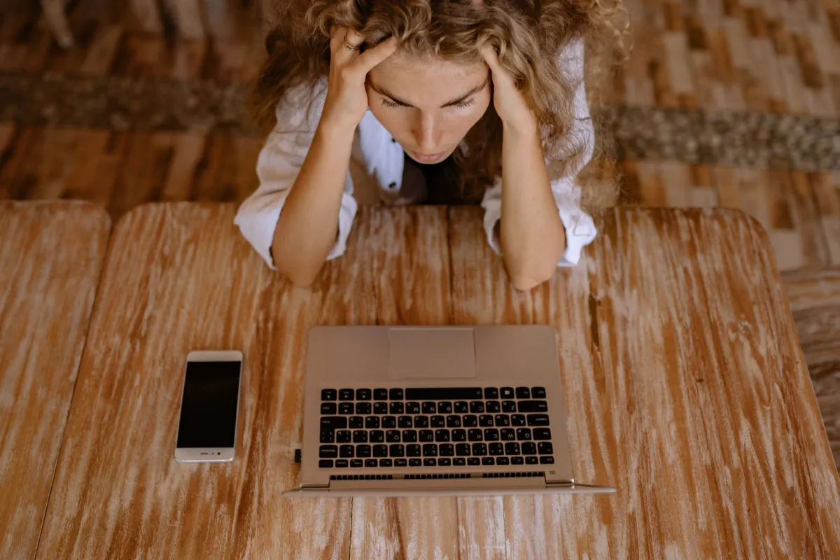 A person looking at their phone with a confused expression, reflecting the moment a post vanishes with no explanation.