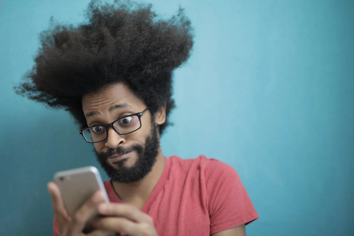 A person checking a phone alone, matching how a removed post looks unchanged only to its author.