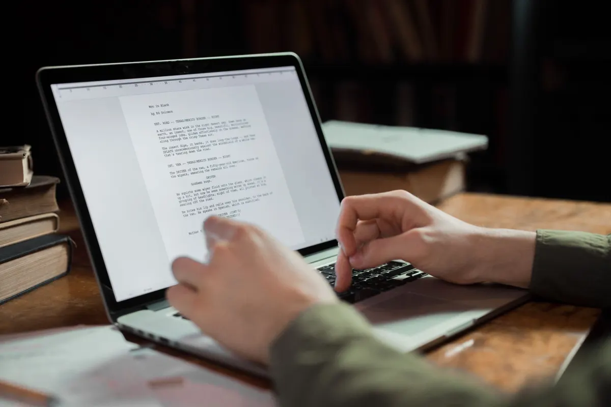 Uma pessoa edita um documento em um laptop, refletindo a etapa de revisão humana antes de publicar qualquer rascunho gerado por IA.