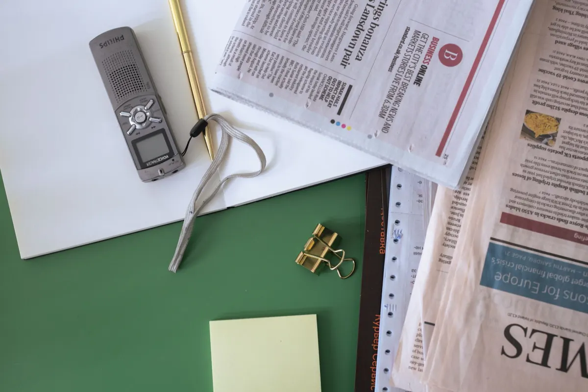 A pair of scissors cutting a newspaper article, the origin of media monitoring as a press clipping service.