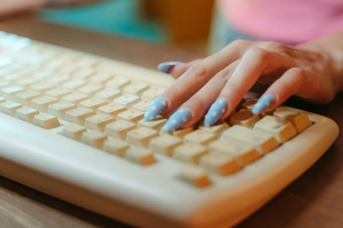 Primer plano de manos escribiendo en un teclado, que representa los comentarios y votos que construyen el karma de una cuenta con el tiempo.