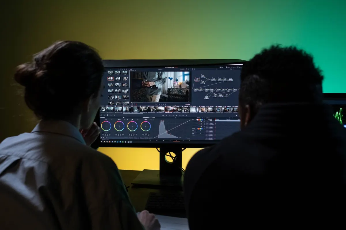Zwei Kollegen lesen gemeinsam auf einem Monitor, wie ein Team, das nach Notes zu Posts über die eigene Marke sucht.
