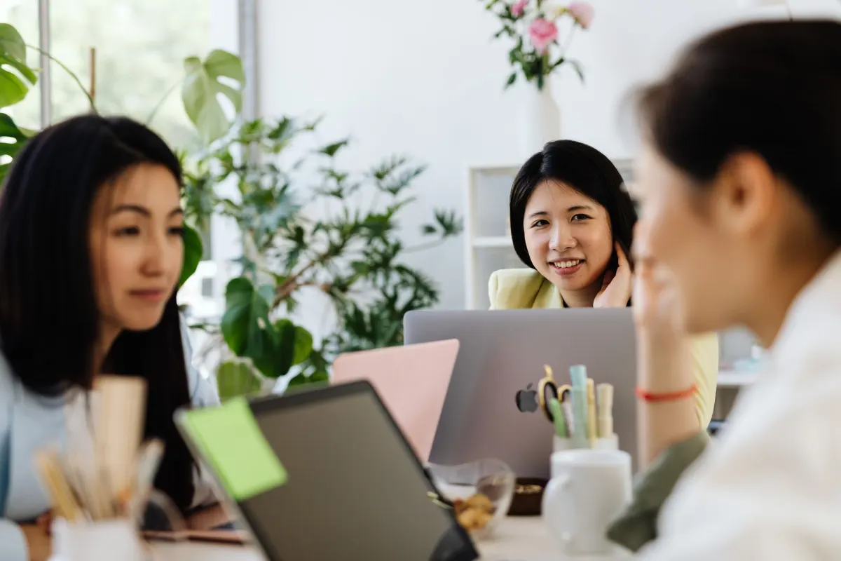 A small team talking over laptops in an office, the kind of group that gets high-intent mentions sent to its chat channel.
